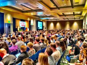 A large audience seated in a conference hall.