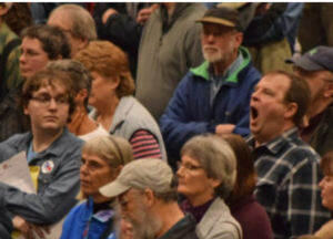 An audience not connecting with speaker, with members yawning, and looking around.
