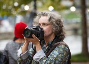A woman manually focusing a camera.