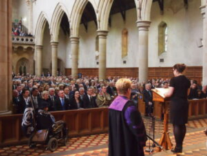 A person delivering a eulogy in a place of worship.