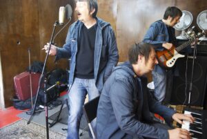 Musicians rehearsing in a small room.