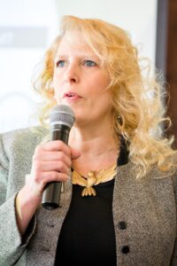 A woman speaking and holding microphone.