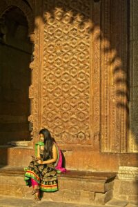 A woman wearing a sari while sitting.
