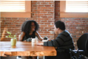 Two people talking in a coffee shop.