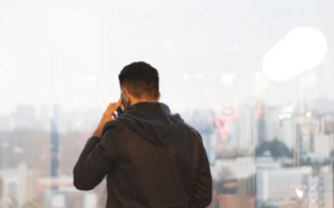 A man talking on a phone, overlooking a city landscape.