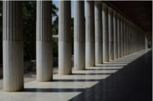 Columns of a building, all the same, with sunlight reflecting in.