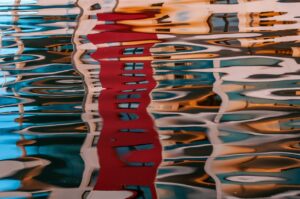 House images reflected abstractly in wavy water.
